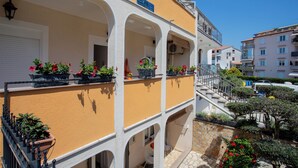 A multi-story building with balconies, outdoor seating, and potted plants. - Lovely Studio Apartment 4 Vrsar, Vrsar, Croatia (Vrsar)