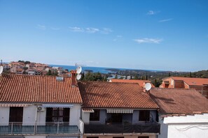 A residential area with terracotta-tiled roofs, satellite dishes, and a clear view of the sea in the background. - Lovely Studio Apartment 5 Vrsar, Vrsar, Croatia (Vrsar)