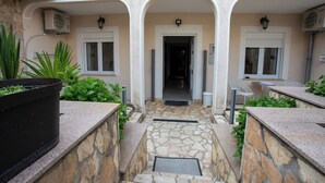 A courtyard with a stone pathway leading to a door, surrounded by plants and outdoor furniture. - Lovely Studio Apartment 5 Vrsar, Vrsar, Croatia (Vrsar)