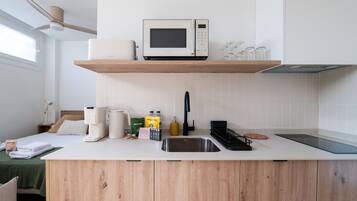 Una cocina moderna con microondas integrado, cafetera y lavabo.