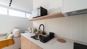 Een moderne keuken met een inbouwvaatwasser, een spoelbak met een zwarte kraan en een houten aanrecht.