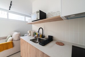 Een moderne keuken met een inbouwvaatwasser, een spoelbak met een zwarte kraan en een houten aanrecht.