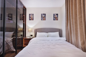 A hotel room with a bed, a nightstand, a lamp, a glass door, and three wall-mounted artworks. - Luxury Rooftop Apartment in VYE Sodic New Zayed – Premium Stay, Pet-Friendly! (Giza Governorate)