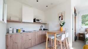 Una cocina moderna con armarios de madera, un microondas y un comedor con mesa y sillas.