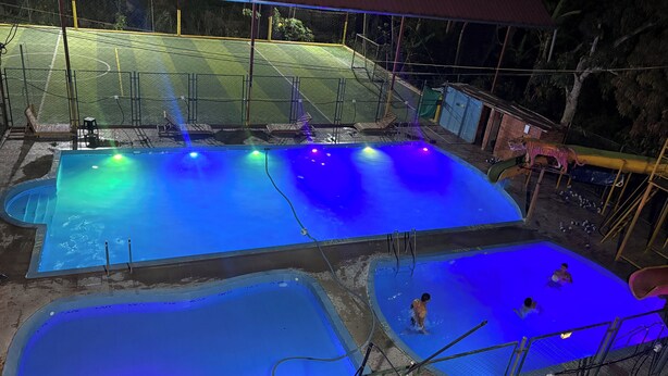 A swimming pool area with multiple pools, a covered seating area, and a small building. - La Jungla del Rey (Shipasbamba)