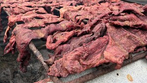 A covered outdoor area with a metal roof, a concrete floor, and a large pile of dried meat. - La Jungla del Rey (Shipasbamba)