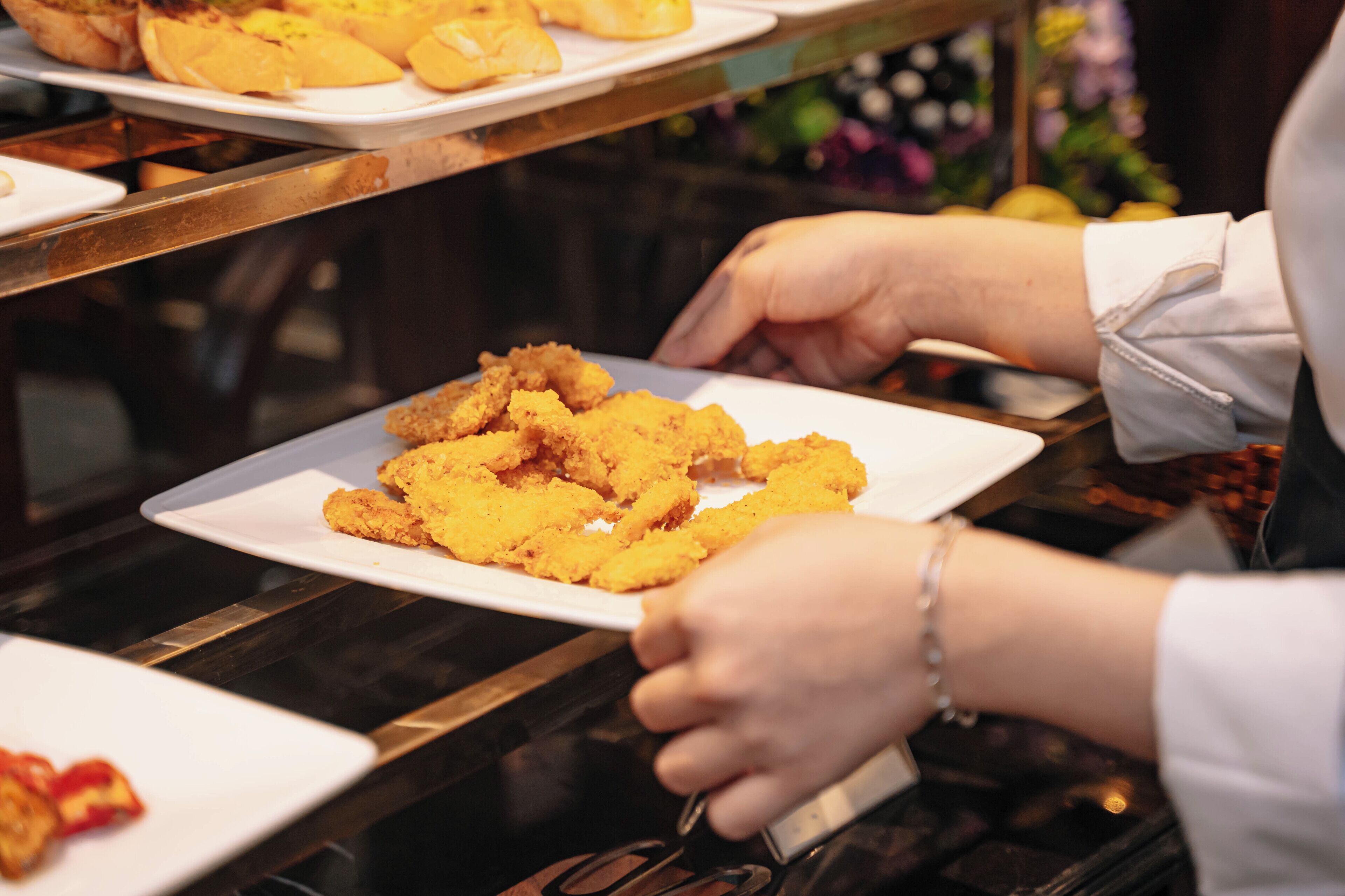 A person serving food on a white plate.