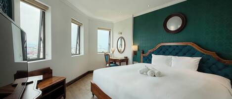 Ein Hotelzimmer mit Bett, Schreibtisch, Stuhl und Spiegel.