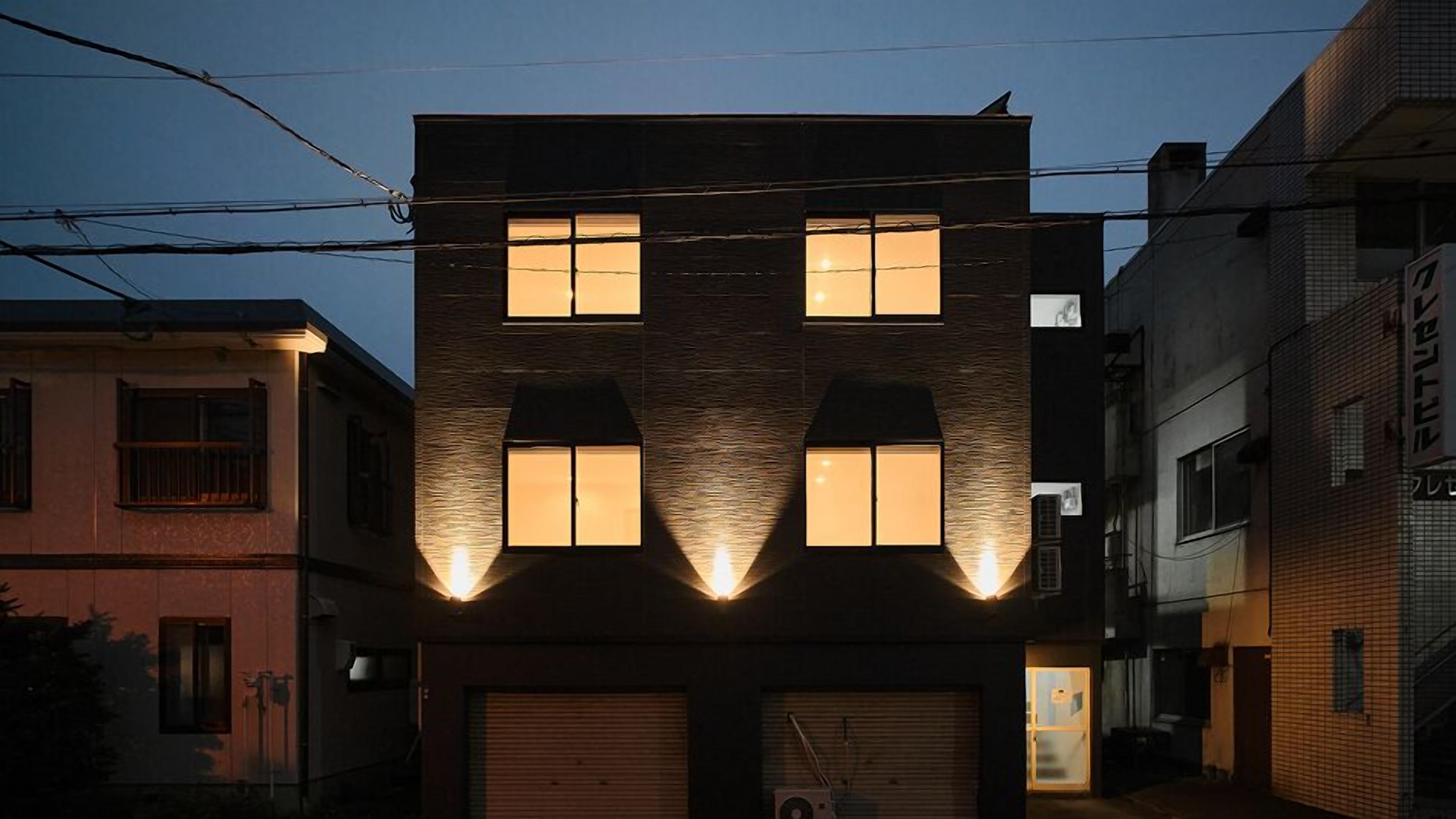 Ein Gebäude mit einer markanten Fassade, die sich durch dreieckige Fenster und eine Garage auszeichnet.