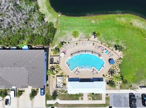 An aerial view of a resort with a swimming pool, lounge area, and parking. - Rae of Sunshine (Panama City Beach)