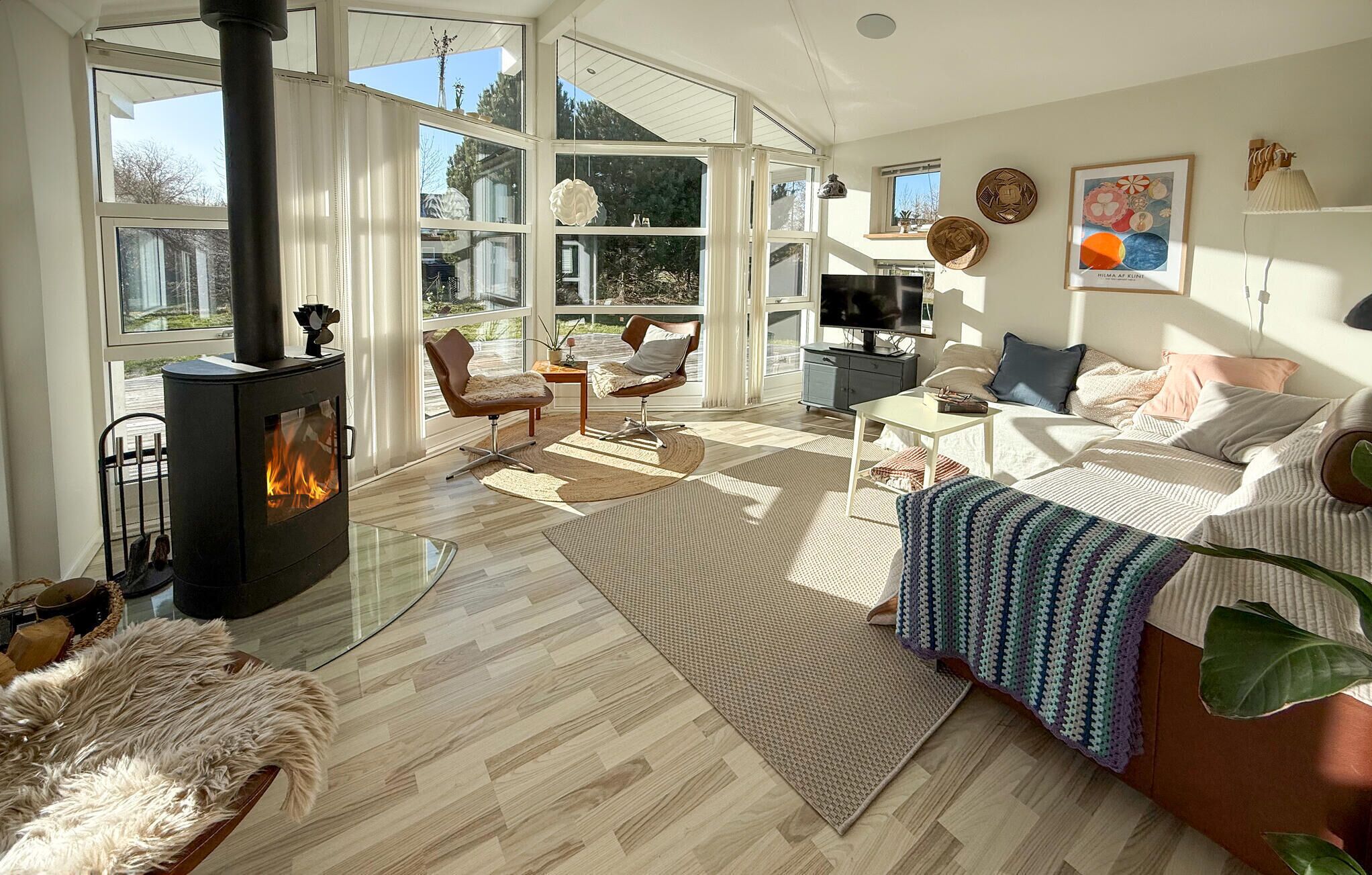 A spacious living room with a fireplace, large windows, and a cozy seating area.