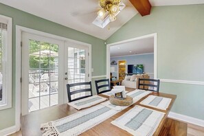 A dining area with a wooden table, chairs, and a ceiling fan.