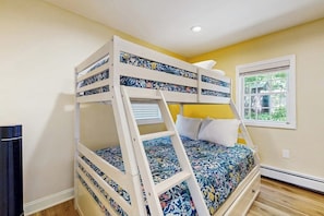 A bunk bed with a ladder, a window with a view, and a heater.