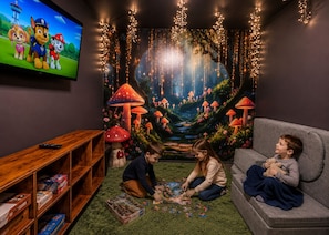 A cozy room with a flat-screen TV, a couch, and a carpeted floor.