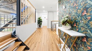 Ein modernes Interieur mit einer Holztreppe, einer Pflanze und einer lebhaften Blütenwand.