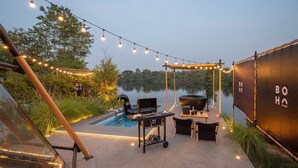 Eine Terrasse im Freien mit Grill, Sitzgelegenheiten und Lichterketten.