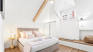 Een moderne slaapkamer met een bed, nachtkastjes en uitzicht.