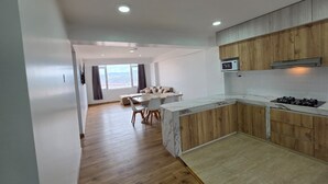Eine moderne Küche mit Holzschränken, einer Marmorarbeitsplatte und einer eingebauten Mikrowelle.