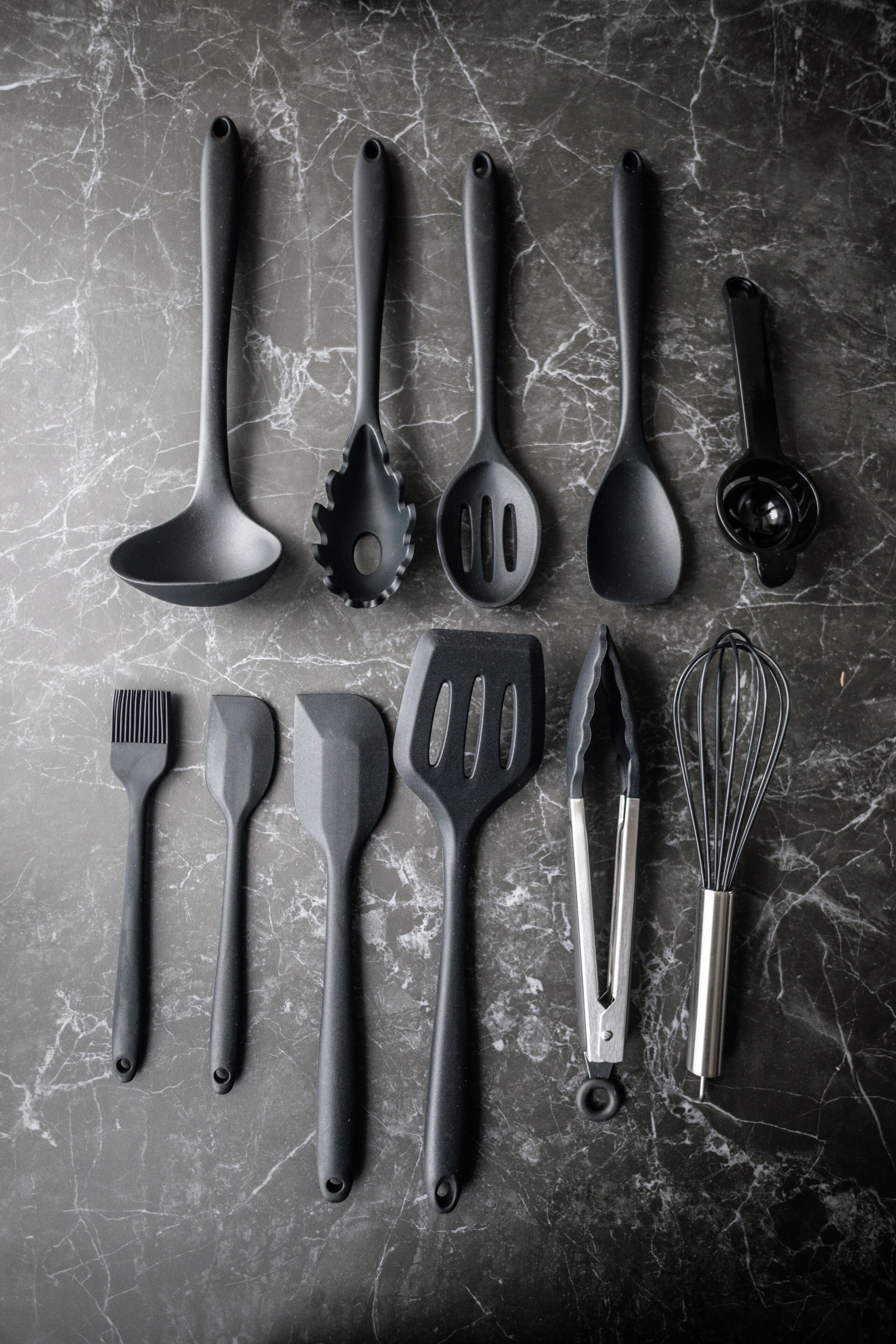 Un ensemble d’ustensiles de cuisine disposés sur une surface en marbre.