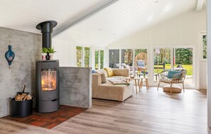A modern living room with a fireplace, comfortable seating, and large windows. - Lovely home in Oksbøl with WiFi (Oksbøl)