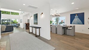 A spacious living area with a dining set, a large window, and artwork on the walls. - Private Mid-Century Oasis 3-bedroom home  in  Los Angeles with Pool/Spa & BBQ (Los Angeles)