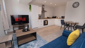 A modern living room with a TV, sofa, and dining area. - Cosy Chic 1BR Haven in Hull Centre Near Marina (Hull)