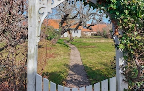 A garden pathway leading to a house with a white fence and a decorative archway. - 4 bedroom beautiful home in Mölle (Mölle)