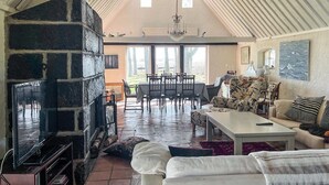 Ein gemütliches Wohnzimmer mit Kamin, Essbereich und einer Couch.