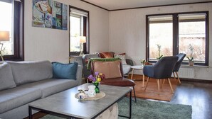 A living room with a sofa, a coffee table, a chair, and a window with a view. - 3 bedroom cozy home in Degeberga (Degeberga)