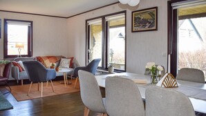 A dining area with a table, chairs, a sofa, and a window with a view of a house. - 3 bedroom cozy home in Degeberga (Degeberga)