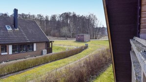A brick house with a sloped roof and a chimney, a small utility shed, and a grassy field with trees in the background. - 3 bedroom cozy home in Degeberga (Degeberga)