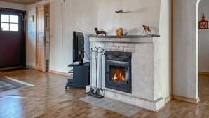 A room with a fireplace, a television, and a door.