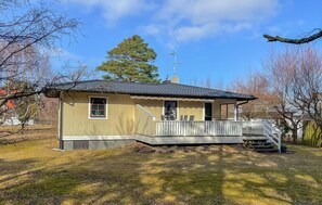A single-story house with a porch, a satellite dish, and a chimney.