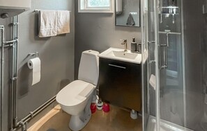 Un baño con inodoro, lavabo y ducha.