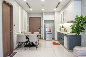 Eine moderne Küche mit Essbereich, einem Kühlschrank und einer Pflanze.