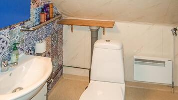 A bathroom with a white sink, toilet, and a shower area.