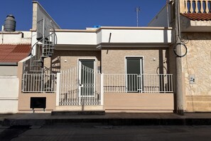 Ein zweistöckiges Gebäude mit einer Metalltreppe, einem verschlossenen Eingang und einer Stein-Fassade.