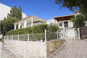A two-story house with a stone staircase leading to the entrance, a white fence, and a gate. - Villa Panoramic | Porto Cesareo beach (Porto Cesareo)