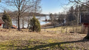 Une propriété au bord du lac, comprenant un petit chalet, un banc en bois et un espace clôturé.
