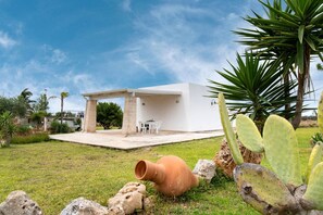 A modern white building with a patio, outdoor seating, and cacti. - La Pennichella Apartments - La Pennichella Apartments - Alba (Nardo)