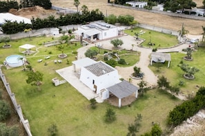 Il s’agit d’une propriété résidentielle comprenant une grande maison, une piscine et un jardin bien entretenu.