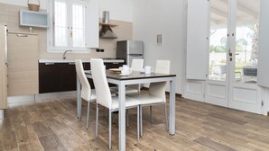 Una cocina compacta con comedor, refrigerador y ventana.