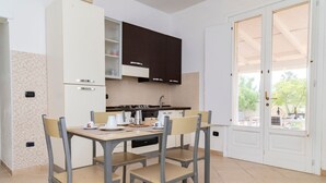 Una cucina moderna con tavolo e sedie, un piano cottura e pensili.