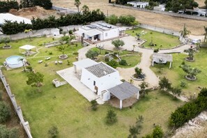 Ein Wohnhaus mit großem Garten, Schwimmbad und gepflegter Grünfläche.