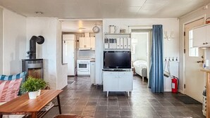 Ett kompakt bostadsutrymme med ett litet kök, en matplats och ett sovrum.