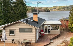 A house with a deck, a chimney, and a view of a lake. - Awesome home in Molkom with lake view (Molkom)
