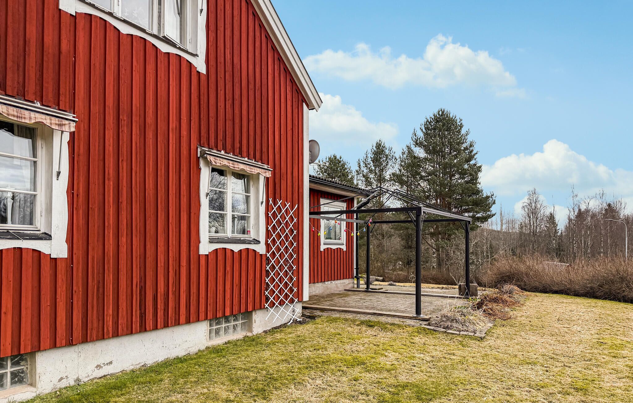 A red barn with a window, a door, and a covered porch area.