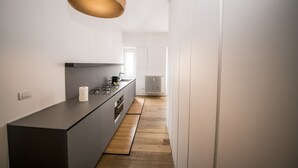 Een moderne keuken met een centraal eiland, een hanglamp en een radiator.