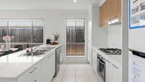 Una cucina moderna con un'isola grande, un lavello doppio e vista sul giardino attraverso una finestra.