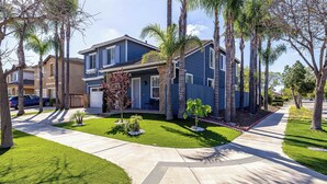A residential neighborhood with houses, palm trees, and a well-maintained lawn. - Oxnard Summer Escape with Pool + Hot Tub (Oxnard)